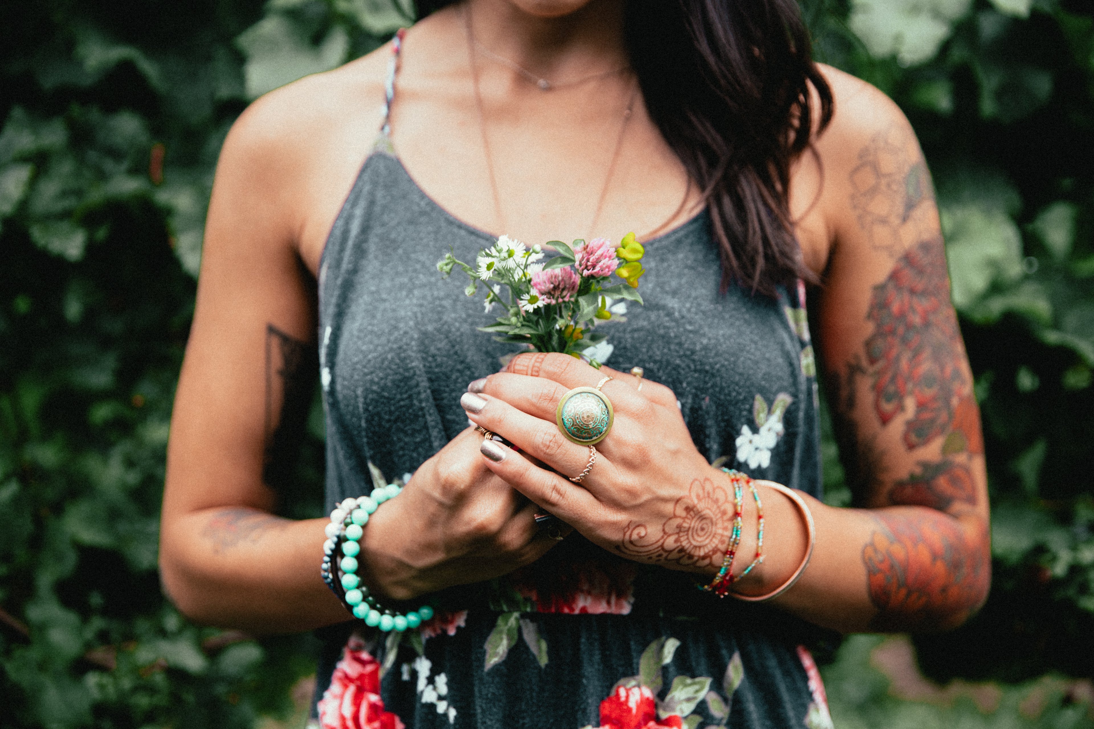 Avenora Atelier high-end jewelry model wearing statement earrings while holding a bouquet of flowers